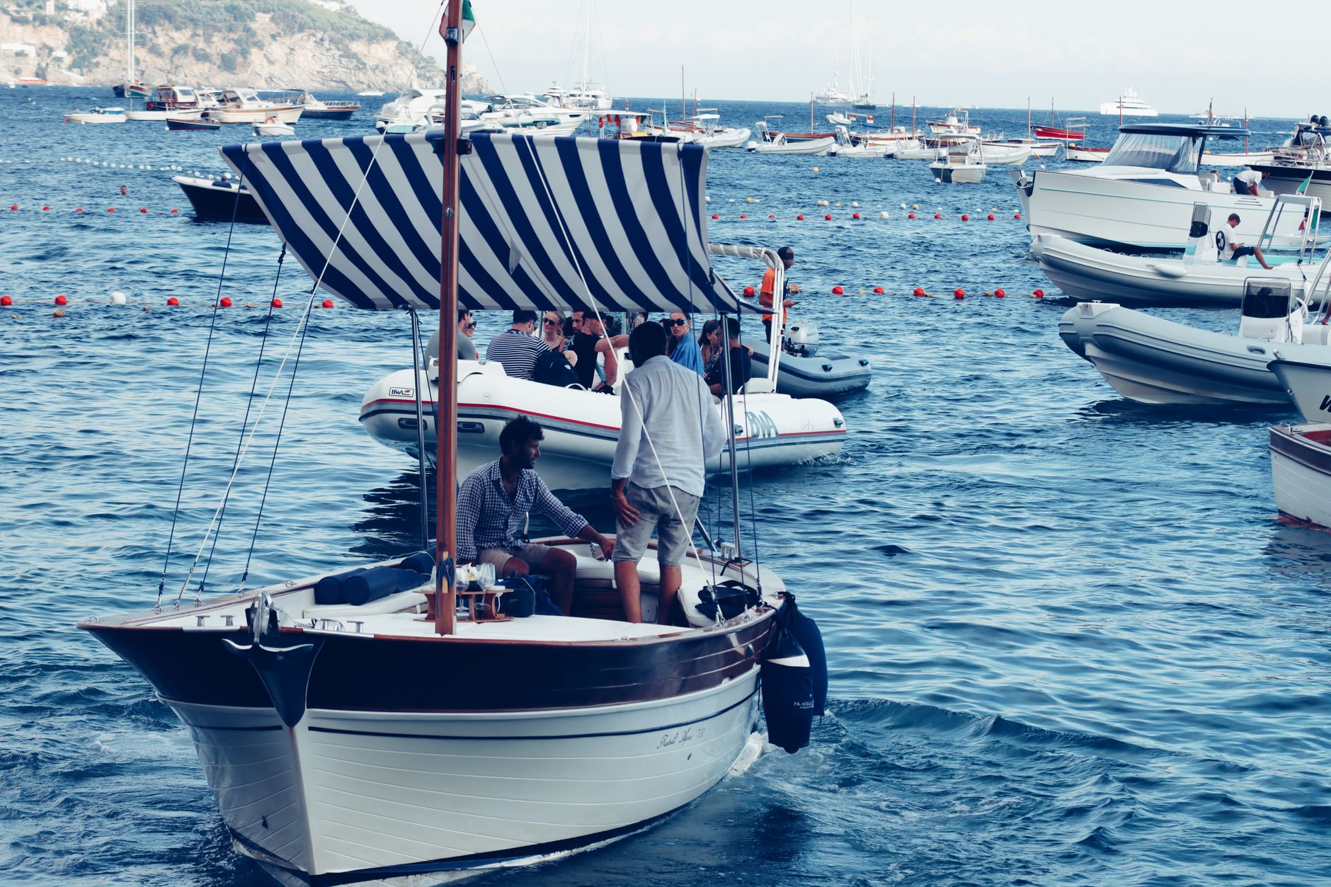 Small rental boats and wooden fishing vessels moored in the rocky harbor of Cala Figuera